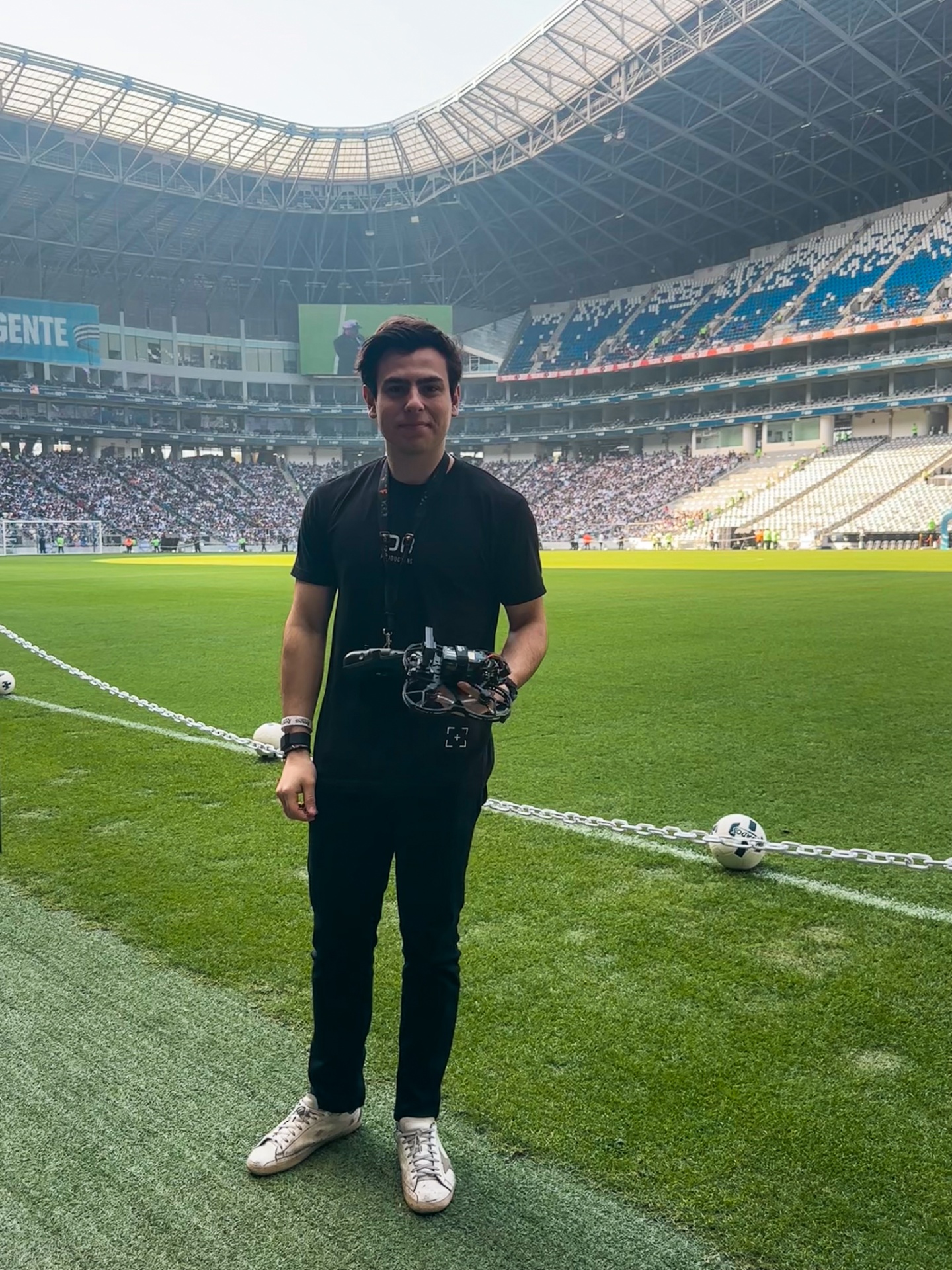 FPV pilot holding cinelifter on the pitch at Estadio BBVA before Rayados match